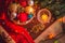 Beautiful cozy christmas scene with xmas tree branch, a small basket with colorful balls, a burning candle, opened book, a garland