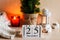 Beautiful cozy home decor composition with candles, lantern, Christmas tree, knitted sweater and calendar. Wooden calendar with