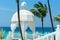 Beautiful cozy inviting white gazebo standing against azure turquoise ocean and blue sky