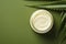 Beautiful cream bottle with beauty products aloe leaves on green background. Natural organic skin care