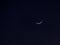 The beautiful crescent moon shining in the dark night sky...