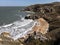 Beautiful Crimean seascape. Empty sandy beach, black rocks and big waves at sea
