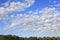 Beautiful cumulus cirrus clouds over forest