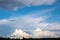 Beautiful cumulus clouds above the dark outline of trees and high stratus clouds