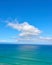 Beautiful cumulus clouds in a blue sky over a calm blue sea and ocean in summer. Gorgeous scenic view of the beach and