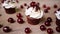 Beautiful cupcake with whipped cream cherry and chocolate on table. Homemade party dessert. Slow motion video.