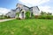 Beautiful curb appeal of large blue house and green front yard.