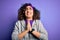 Beautiful curly arab sportswoman doing sport wearing sportswear over purple background begging and praying with hands together