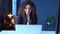 Beautiful curly businesswoman in a suit works while sitting at a table with a laptop in a cozy office or coworking space