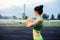 Beautiful curly girl flexing muscles in the stadium. Warm up with the ball. The girl goes in for sports. Light green tracksuit