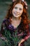 Beautiful curly girl holding flowering heather