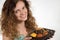 Beautiful curly girl holding a foul banana, lemon and tangerine