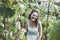 Beautiful curly hair girl in a light blue simple dress in a vineyard