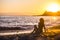 Beautiful curly hair nice model woman middle age young sitting at the beach enjoying the freedom and the relaxed sunset with