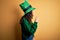 Beautiful curly hair woman wearing green hat with clover celebrating saint patricks day looking to side, relax profile pose with