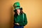 Beautiful curly hair woman wearing green hat with clover celebrating saint patricks day thinking looking tired and bored with