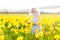 Beautiful curly toddler girl field of yellow daffodil flowers