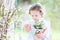 Beautiful curly toddler girl with first spring flowers