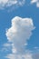 Beautiful curly white cloud in the blue sky in sunny weather, vertical and format