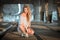 Beautiful curly young woman sitting on industrial bridge location