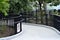 Beautiful curve concrete pathway with metal railing in the green park.