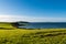 Beautiful curving shoreline of lush green, grassy fields