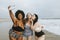 Beautiful curvy women taking a selfie at the beach