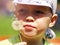 Beautiful cute boy in park blowing on dandelion in summer time, so close