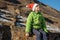 Beautiful cute boy sitting against the background of the mountains dressing Santa hat and looks into the clouds. new