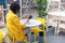 Beautiful cute brunette in a yellow jacket. Young businesswoman in a cafe using a digital tablet running. Freelance