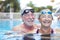 Beautiful and cute close up of two seniors in the pool having fun together - fitness and healthy lifestyle - summertime together