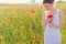 Beautiful cute gentle girl in white dress in the poppy field with a bouquet of poppies in the hands of