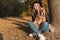 Beautiful cute happy girl in a black hat playing with her dog in a park in autumn another sunny day