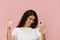 beautiful cute woman with a trendy phone in her hands stands on a pink background in a white t-shirt, holds her thumb up