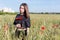 Beautiful cute young woman with full lips with short hair in a field with poppy flowers in their hands