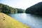 Beautiful dam with embankment background. Secenery view of reservoir with trees and water
