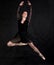 Beautiful dancer studio portrait jumping on black background.