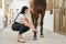 Beautiful dark haired girl bandaging horse legs