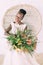 Beautiful dark skin bride. Beautiful african american bride with tropical bouquet in studio, sitting in the chair