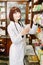 Beautiful darkhaired lady pharmacist choosing the product in drugstore