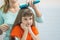 A beautiful daughter looks cute in mirror while Mom combs her hair