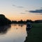 Beautiful dawn landscape image of River Thames at Lechlade-on-Thames in English Cotswolds countryside with swan in misty river