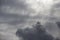 Beautiful day cloudscape view from below of dramatic dramatic grey and white thunder storm clouds on a dark sky background