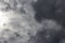 Beautiful day cloudscape view from below of dramatic dramatic grey and white thunder storm clouds on a dark sky background