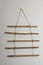 Beautiful decor element made of dry bamboo sticks hanging on white wall