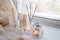 Beautiful decor of white lighted candles in glass candlesticks stand on windowsill, relax place in house, concept of winter cozy