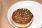 Beautiful decorated Hanukkah donut on a white plate.