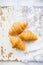 Beautiful and delicious croissants on the background of old laces and white table