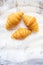 Beautiful and delicious croissants on the background of old laces and white table