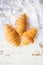 Beautiful and delicious croissants on the background of old laces and white table